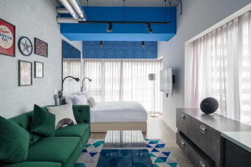 香港Southside by Ovolo的客厅配有绿色沙发和床。