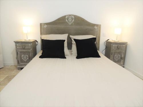 TavernesL’écurie location saisonnière的一张大床,配有两个床头柜和两盏灯