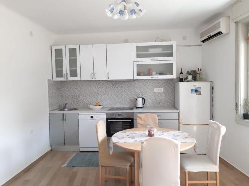 斯普利特市中心尼娜公寓的厨房配有桌椅和冰箱。