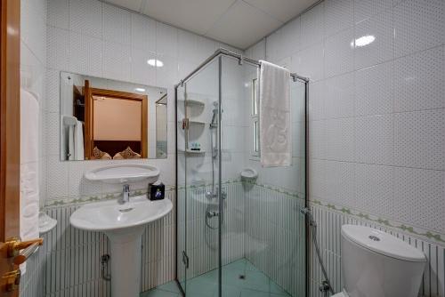 迪拜J5 Four Bedroom Villa Holiday home in Mirdif的一间带玻璃淋浴和水槽的浴室