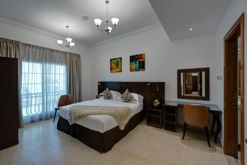 迪拜J5 Four Bedroom Villa Holiday home in Mirdif的一间卧室配有一张床、一张书桌和一面镜子