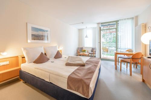 奥斯特巴德·哥伦吕根岛高堤公寓式酒店的一间带大床的卧室和一间餐厅