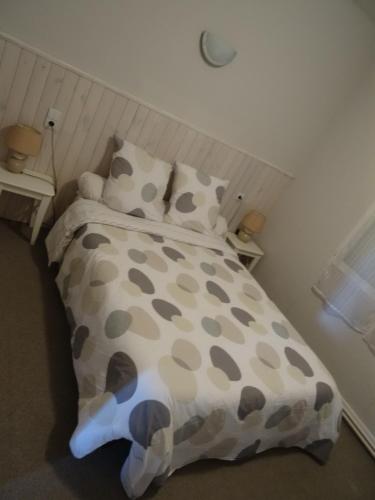 Alban热烈欢迎酒店的一张带棕色和白色棉被和枕头的床
