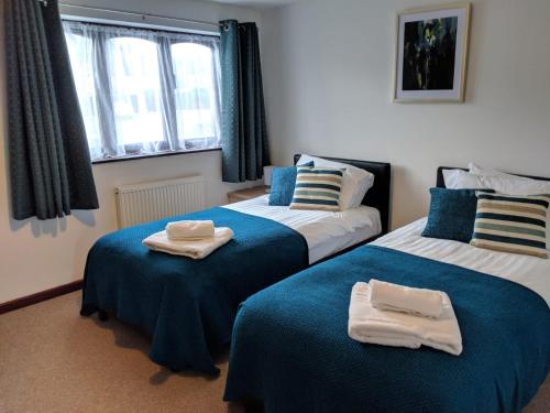特尔福德Princes Lodge的一间卧室配有两张带毛巾的床
