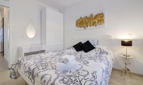 塞尼Apartments Luka - Villa Sunce的白色卧室配有一张带黑白色棉被的床