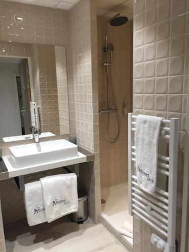 萨兰HOTEL LES 3 VALLÉES的浴室配有水槽、淋浴和毛巾
