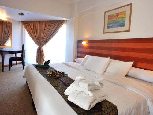 瓜拉丁加奴报春花海滩酒店的酒店客房带一张大床,带毛巾