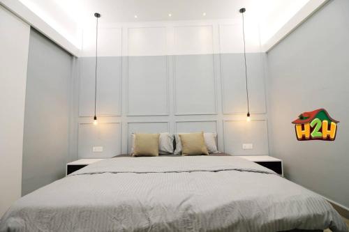 怡保H2H - Sweet Cottage - Octagon的卧室配有一张带白色墙壁的大床
