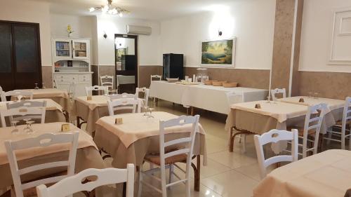 切萨雷奥港阿尔伯格普利玛维拉旅馆的用餐室配有桌子和白色的桌椅