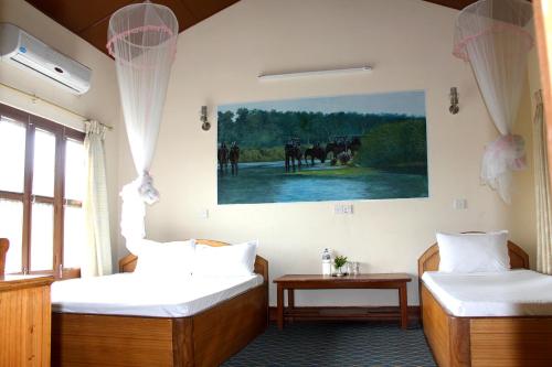 索拉哈Rhino Land Jungle Lodge的墙上画画的房间里设有两张床