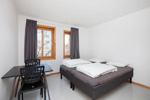 奥斯陆Anker Hostel的一间卧室配有一张床、一张书桌和一个窗户。