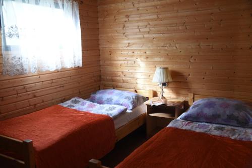 姆热日诺Nestor Domki的木间设有两张床,设有窗户