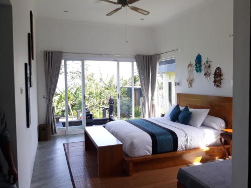 贝都古Wanagiri Cosmic Nature Villa的一间卧室设有一张床和一个大窗户