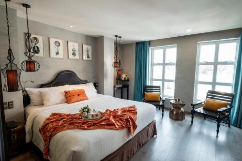 胡志明市三诺娃西贡酒店的一间卧室配有一张大床,上面有橙色毯子