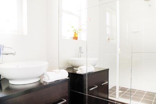 AngastonAngaston Mews Apartments的白色的浴室设有水槽和淋浴。