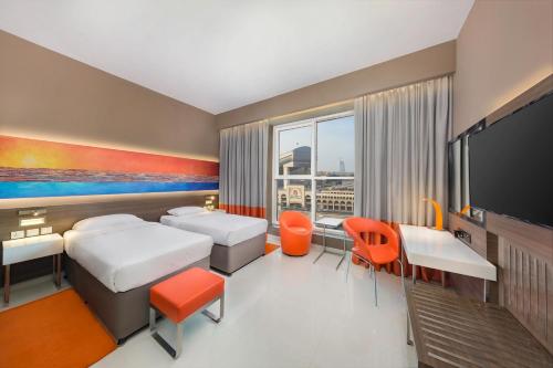 迪拜Citymax Hotel Al Barsha的酒店客房设有两张床和一台平面电视。