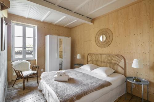 圣马洛La Hune by Cocoonr的一间卧室配有一张大床和一把椅子