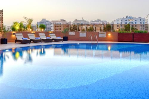 迪拜Majestic City Retreat Hotel的大楼屋顶上的大型游泳池