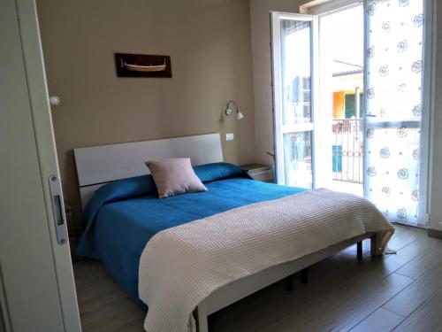 巴韦诺Danilo Apartments的一间卧室配有一张带蓝色毯子的床和窗户。