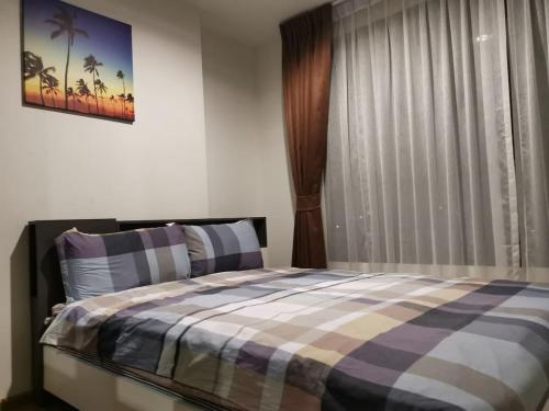 普吉镇4 Floor - Centrio Condominium in Phuket town的一间卧室配有一张带铺着平底毯的床