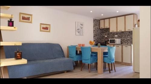 ProžuraCharming House Lovro的客厅配有沙发和带蓝色椅子的桌子