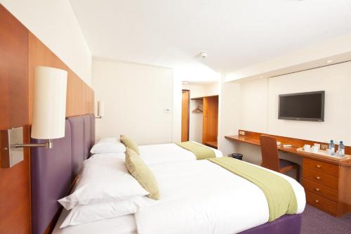 曼彻斯特你好酒店的配有一张床和一张书桌的酒店客房