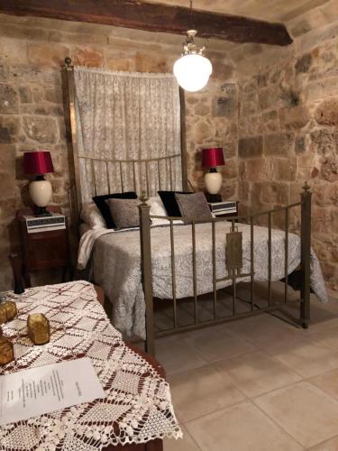MġarrTa Skorba Farmhouse Mgarr的一间卧室配有一张床、两张桌子和两盏灯。