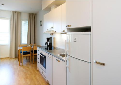 坦佩雷Cozy Central Studio Tampere的厨房配有白色冰箱和桌子