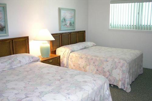 大洋城Barefoot Country 508的酒店客房,设有两张床和一盏灯