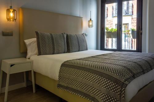 马德里Arenal Suites Puerta del Sol的一间卧室设有一张大床和窗户