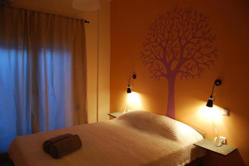 约阿尼纳Lake view apartment的卧室配有一张床铺,墙上挂着一棵树