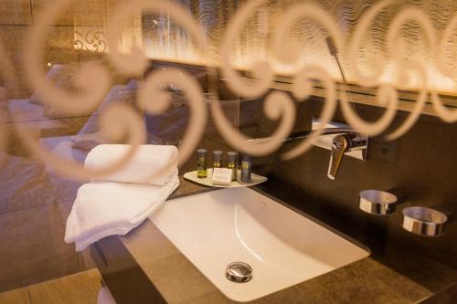 施韦格阿尔卑Säntis - das Hotel的一间带水槽和毛巾的浴室