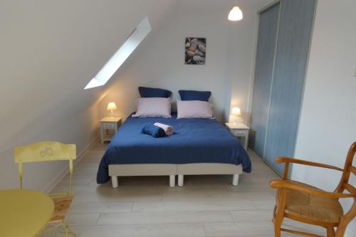 吉尔维内克Brise Océane的一间卧室配有一张带蓝色床单和粉红色枕头的床。