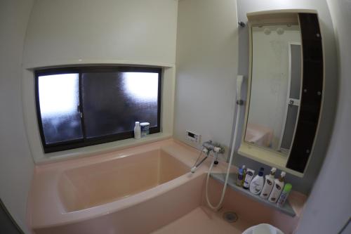 近江八幡市Guesthouse Omihachiman的带浴缸的浴室和窗户。