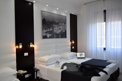 米兰佩鲁吉诺酒店的卧室配有两张床,墙上挂着一幅画