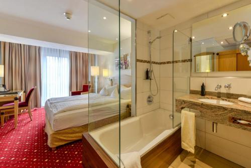 梅彭普克酒店的卧室旁的浴室设有床和浴缸