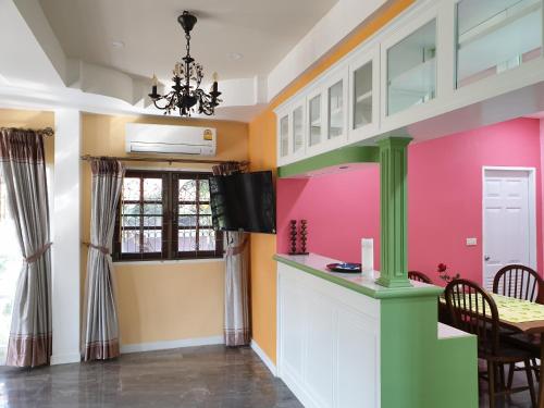 梭桃邑Single House Sattahip的厨房设有粉红色和黄色的墙壁和桌子