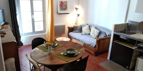阿尔勒Le nid des Arènes的客厅配有桌子和沙发