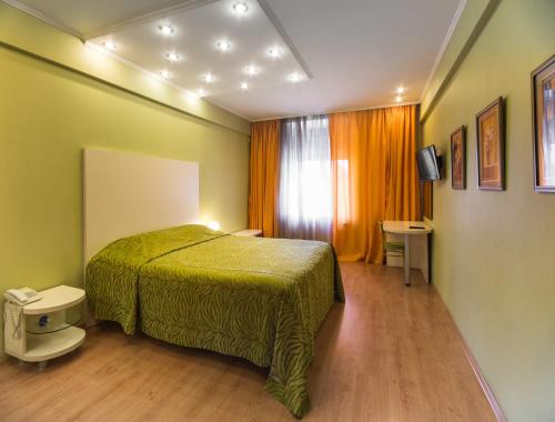 基希讷乌艾德罗萨酒店公寓的一间卧室设有一张绿色的床和一个窗户。