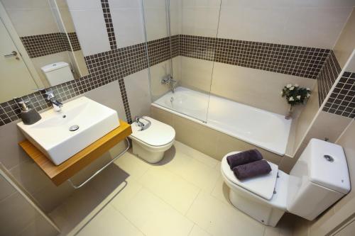 坎布里尔斯Tropicana Planet Costa Dorada的浴室配有盥洗盆、卫生间和浴缸。