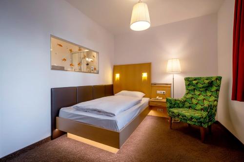 维也纳阿尔特多瑙河海滩酒店的配有一张床和一把椅子的酒店客房