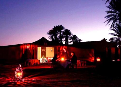 姆哈米德Nomad Life Style的一群人晚上坐在房子前面