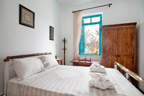 北尼科西亚Bougainvillea Garden的一间卧室配有一张带白色床单的床和一扇窗户。