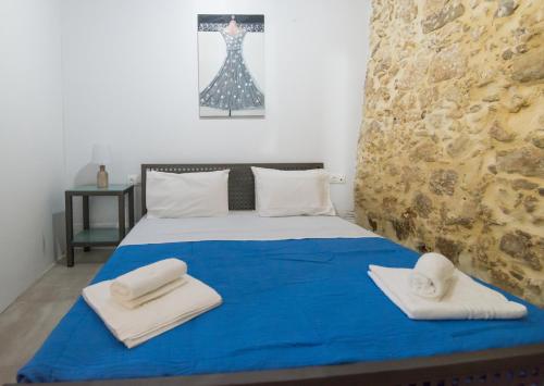 马鲁拉斯Veranda Apartment的一间卧室配有蓝色的床和毛巾