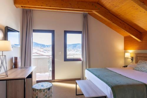 哈卡哈卡皇家水疗酒店的卧室配有一张床、一张书桌和窗户。