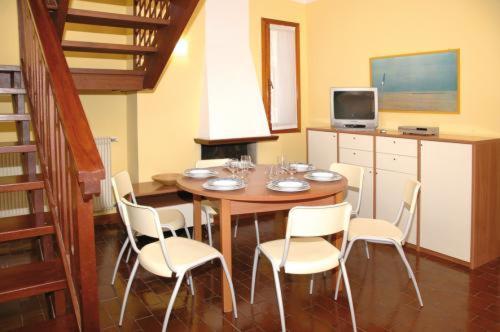 利尼亚诺萨比亚多罗Villa delle Terme的一间带桌子和白色椅子的用餐室