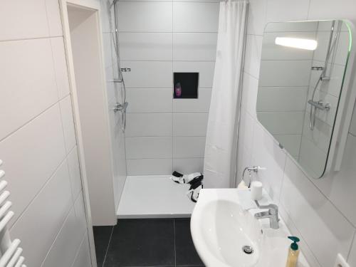 伊本比伦Pension Pommernweg Ibbenbüren的白色的浴室设有水槽和淋浴。