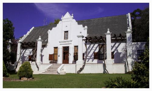 斯泰伦博斯Mooiplaas Wine Estate的白色的房子,设有楼梯和屋顶