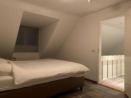 德吕嫩Vakantie huisjes Duinrand Drunen的一间卧室,在阁楼上设有床和窗户
