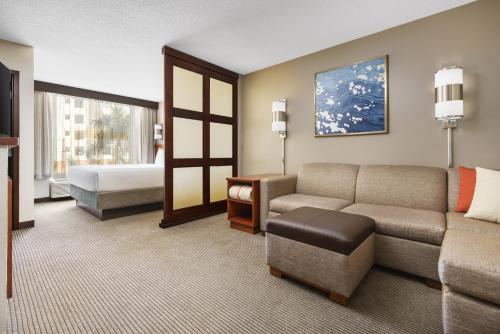 达尼亚滩劳德代尔堡机场/邮轮港凯悦广场堡酒店的客厅配有沙发和1张床